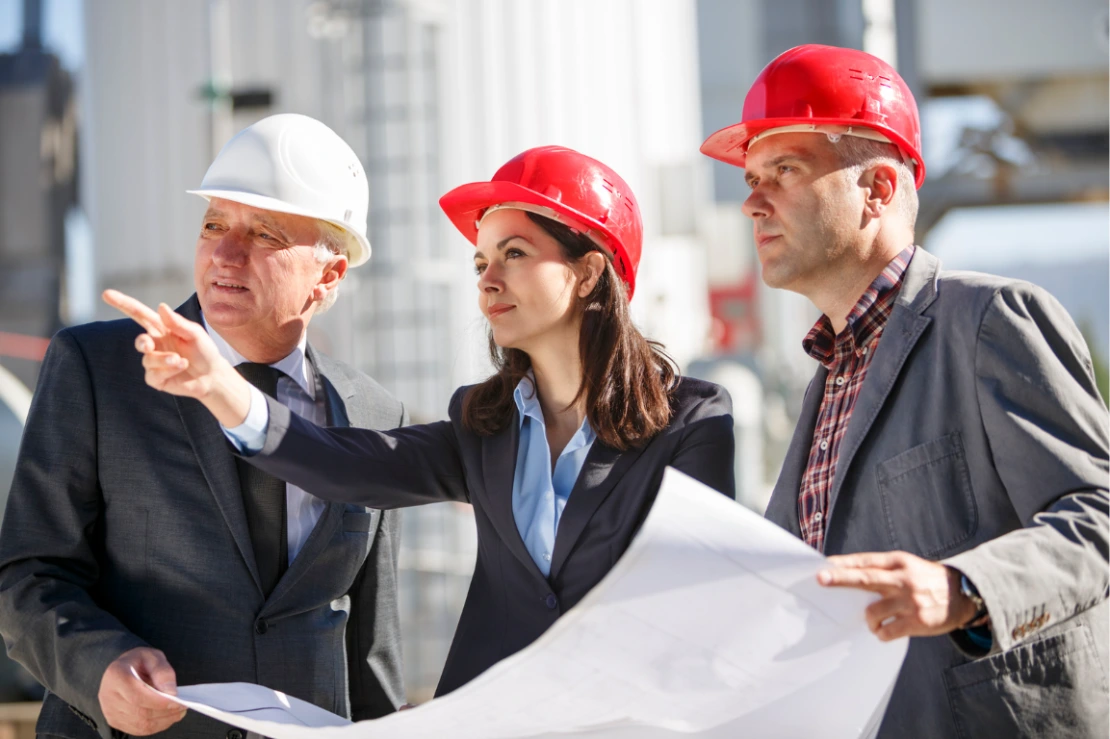Équipe en casques de chantier consultant un plan d'installation